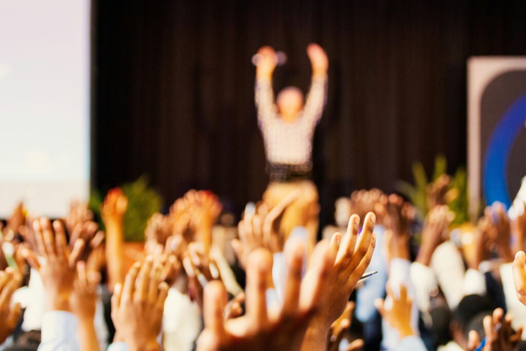 How To Craft Better Call For Papers At University Events 4 Conference Speakers Motivating Large Crowd With Their Hands In The Air Demonstrating Benefits Of A Good Call For Papers